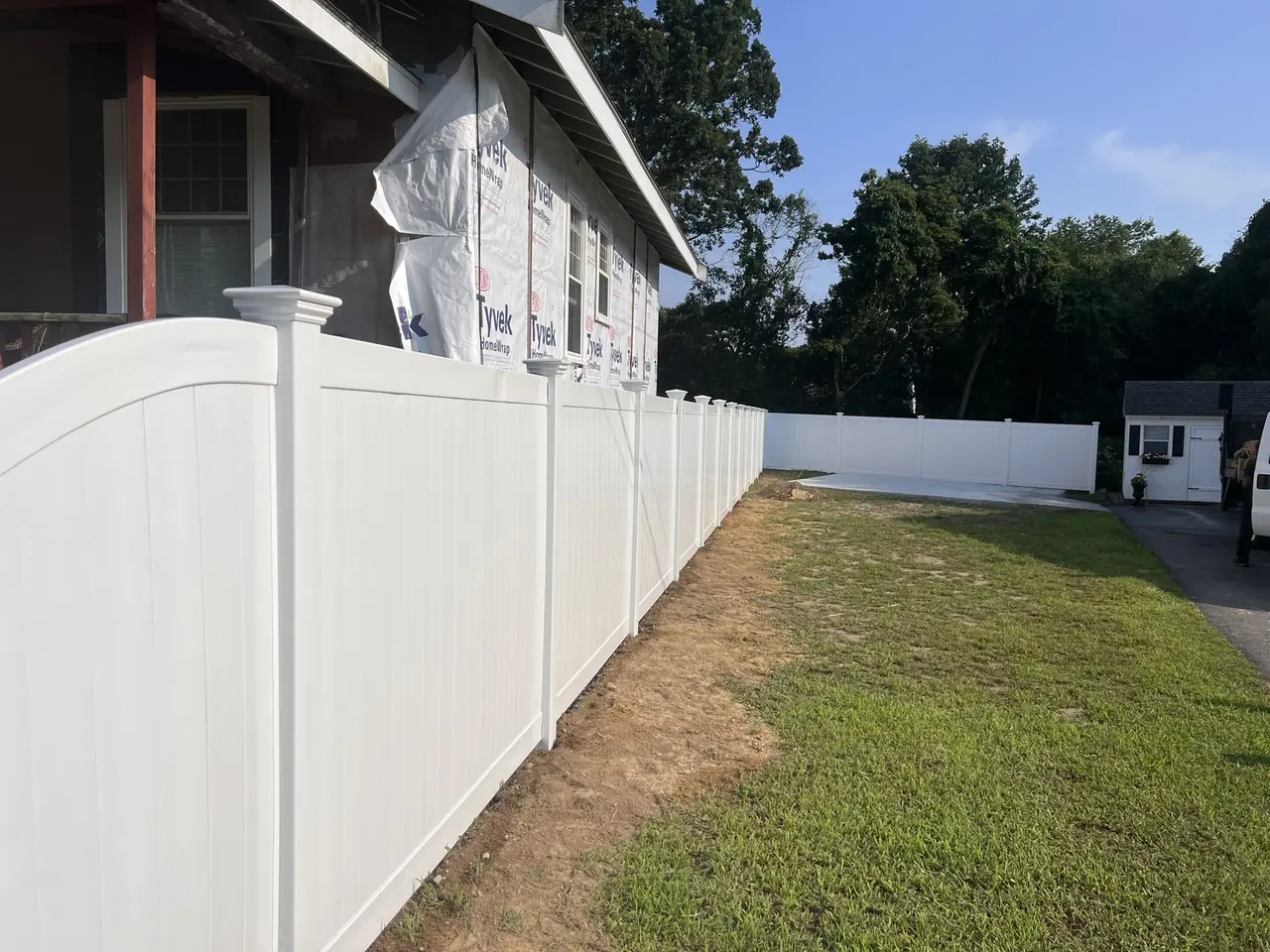 White vinyl privacy fence installed along the side of a home by DM Fence Inc